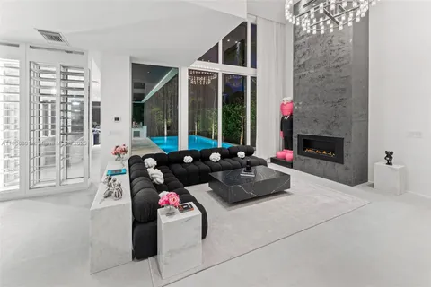 a living room with furniture potted plant floor to ceiling window and potted plants