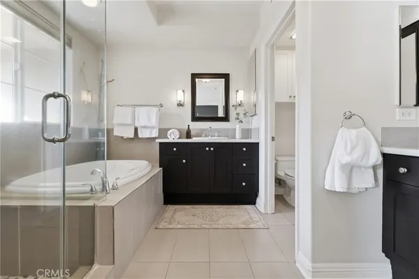 a spacious bathroom with a tub sink and mirror