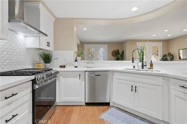 a kitchen with white cabinets stainless steel appliances and sink