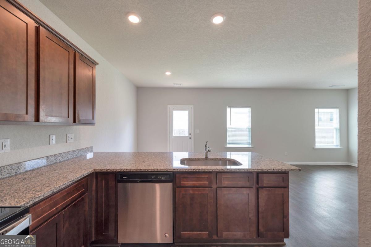 2889 Cleburne Terrace Hampton, GA 30228 - Photo 11 of 25 a kitchen with stainless steel appliances granite countertop a sink a stove cabinets and wooden floor