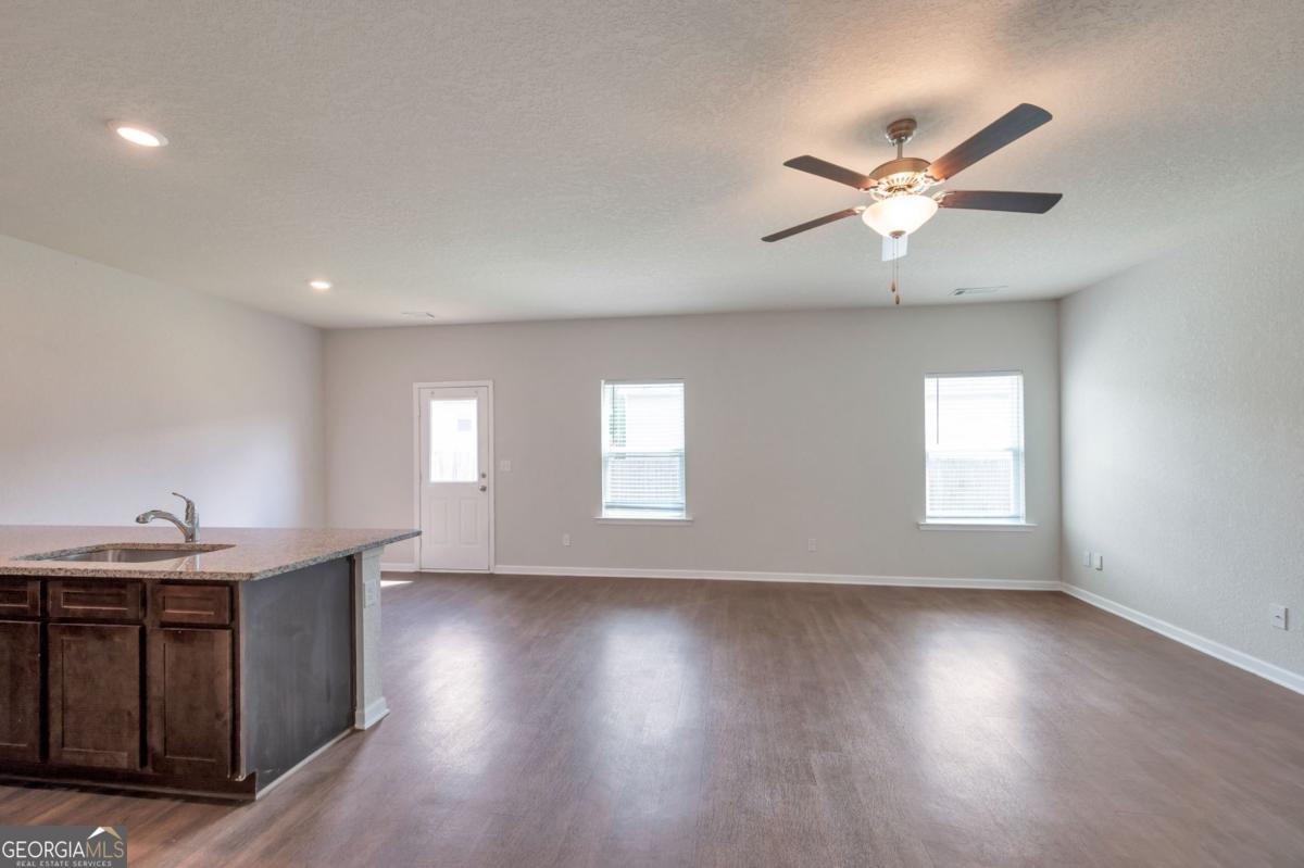 2889 Cleburne Terrace Hampton, GA 30228 - Photo 13 of 25 a view of an empty room with a window and wooden floor