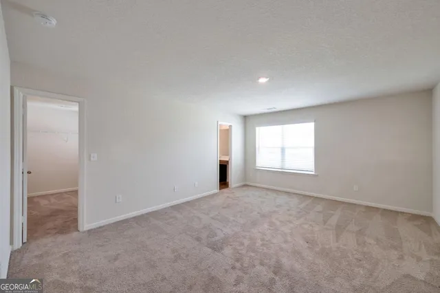 an empty room with windows and closet