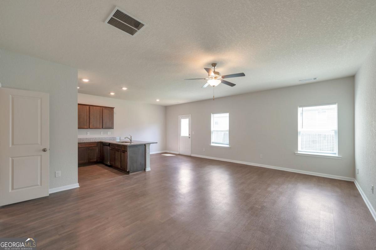 2889 Cleburne Terrace Hampton, GA 30228 - Photo 3 of 25 a view of an empty room with a window and wooden floor