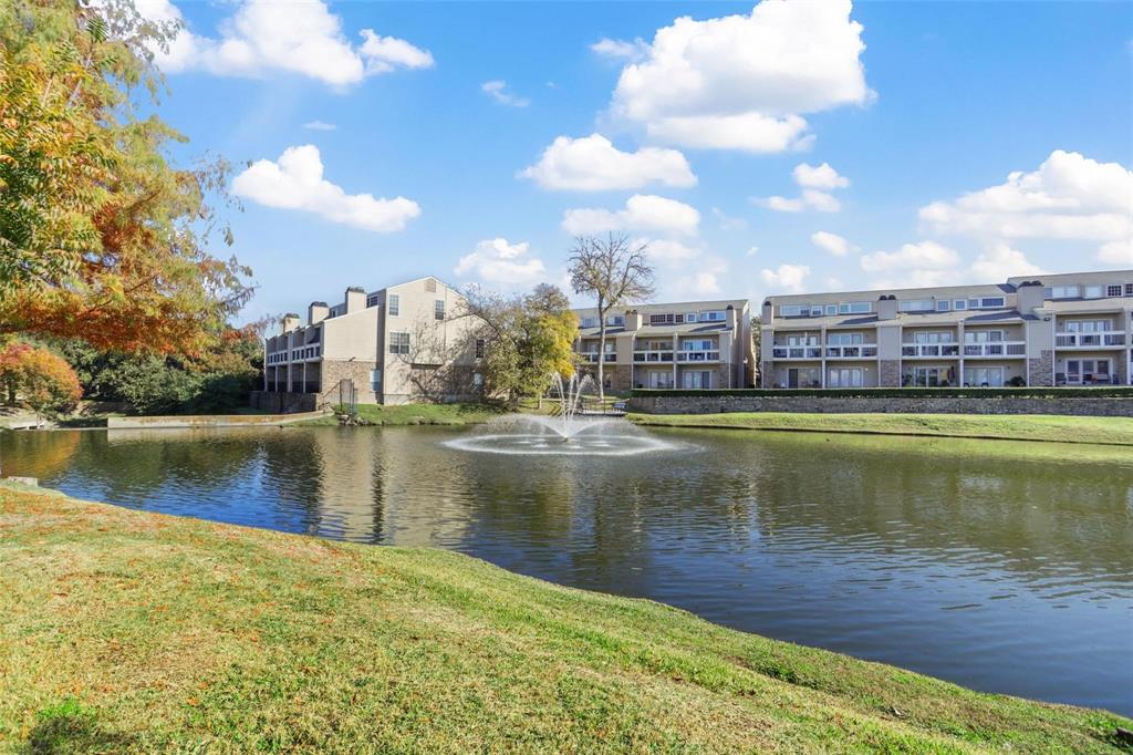 14333 Preston Road, Unit 1704 Dallas, TX 75254 - Photo 16 of 19 Lakefront property featuring a water fountain, multiple balconies, and a manicured grassy area