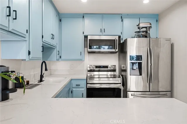 a kitchen with stainless steel appliances a refrigerator a stove a microwave and cabinets