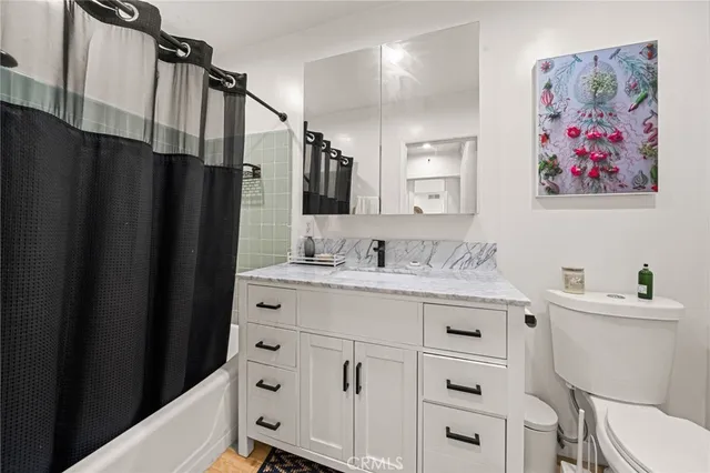 a bathroom with a sink a toilet and a large mirror