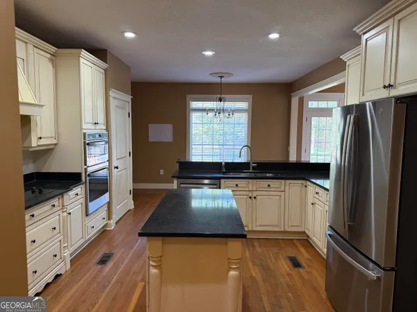 a kitchen with stainless steel appliances granite countertop a stove and a refrigerator