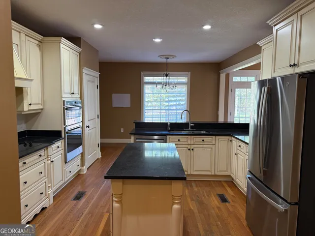 a kitchen with stainless steel appliances granite countertop a stove and a refrigerator