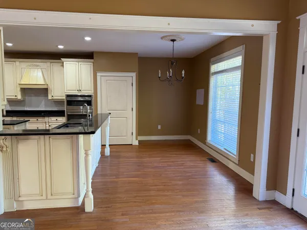 a kitchen with stainless steel appliances a sink a stove and a refrigerator with wooden floor