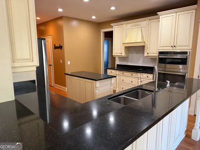 a kitchen with granite countertop a refrigerator and a sink