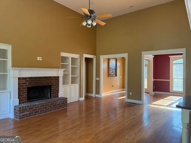 a view of an empty room with glass door and a fireplace