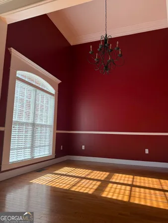 a view of empty room with window and wooden floor