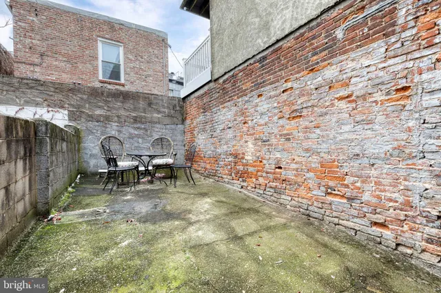a view of a backyard with table and chairs and a fireplace