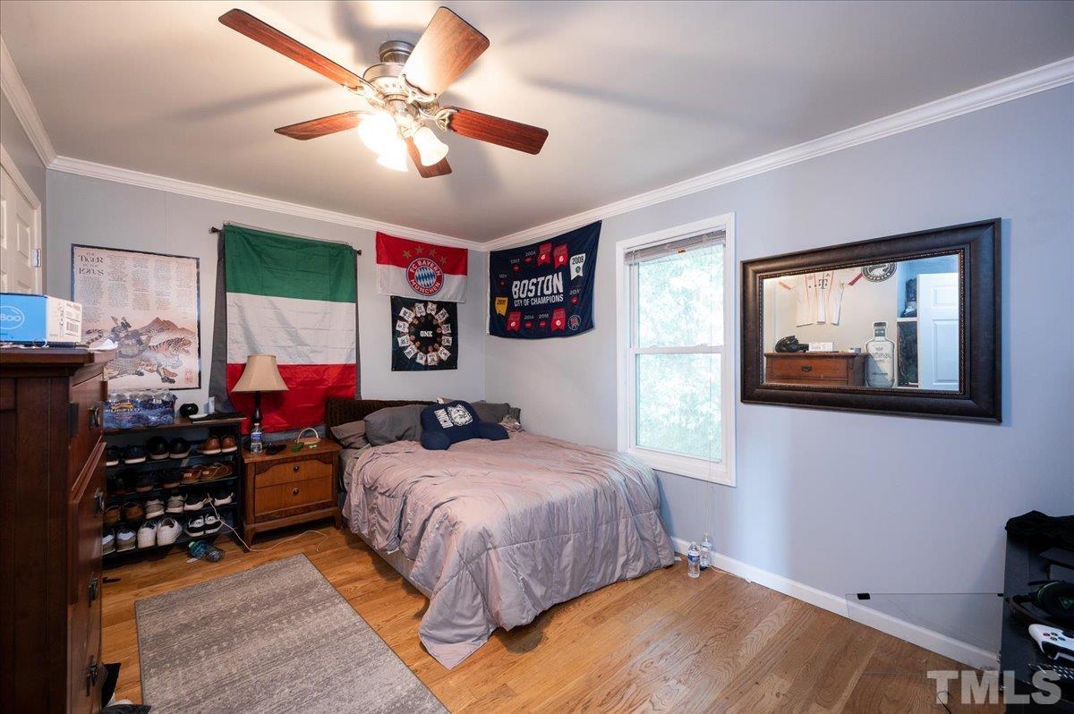 302 Georgetown Road Raleigh, NC 27608 - Photo 11 of 19 a bedroom with bed and a chandelier
