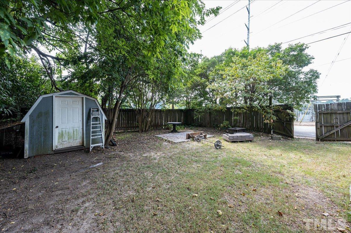 302 Georgetown Road Raleigh, NC 27608 - Photo 16 of 19 a view of a backyard with a small cabin and a chair