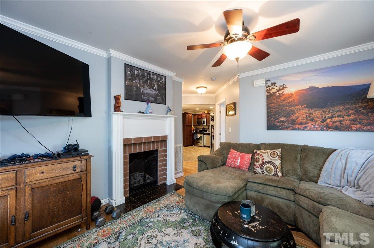 302 Georgetown Road Raleigh, NC 27608 - Photo 5 of 19 a living room with furniture a flat screen tv and a fireplace