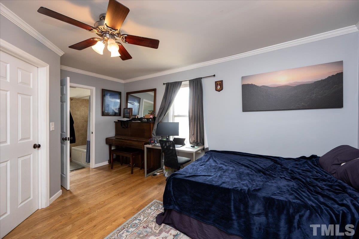 302 Georgetown Road Raleigh, NC 27608 - Photo 10 of 19 a bedroom with a bed and a chandelier