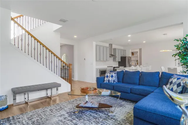 a kitchen with stainless steel appliances granite countertop a sink a stove a dining table and chairs