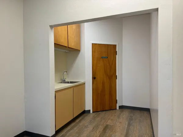 a view of kitchen with wooden floor and cabinets
