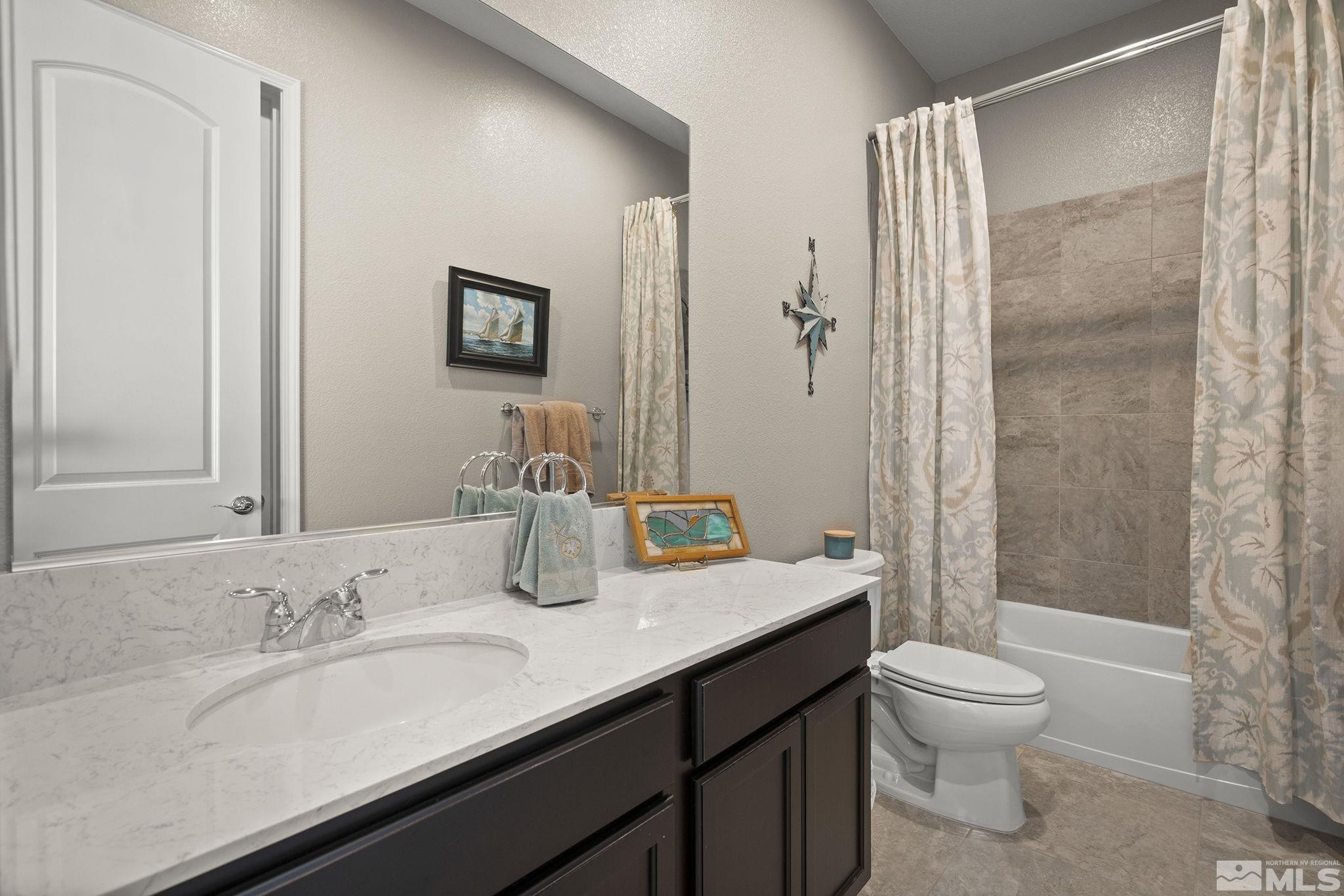 2975 Show Jumper Lane Reno, NV 89521 - Photo 20 of 32 a bathroom with a granite countertop sink toilet a mirror and shower
