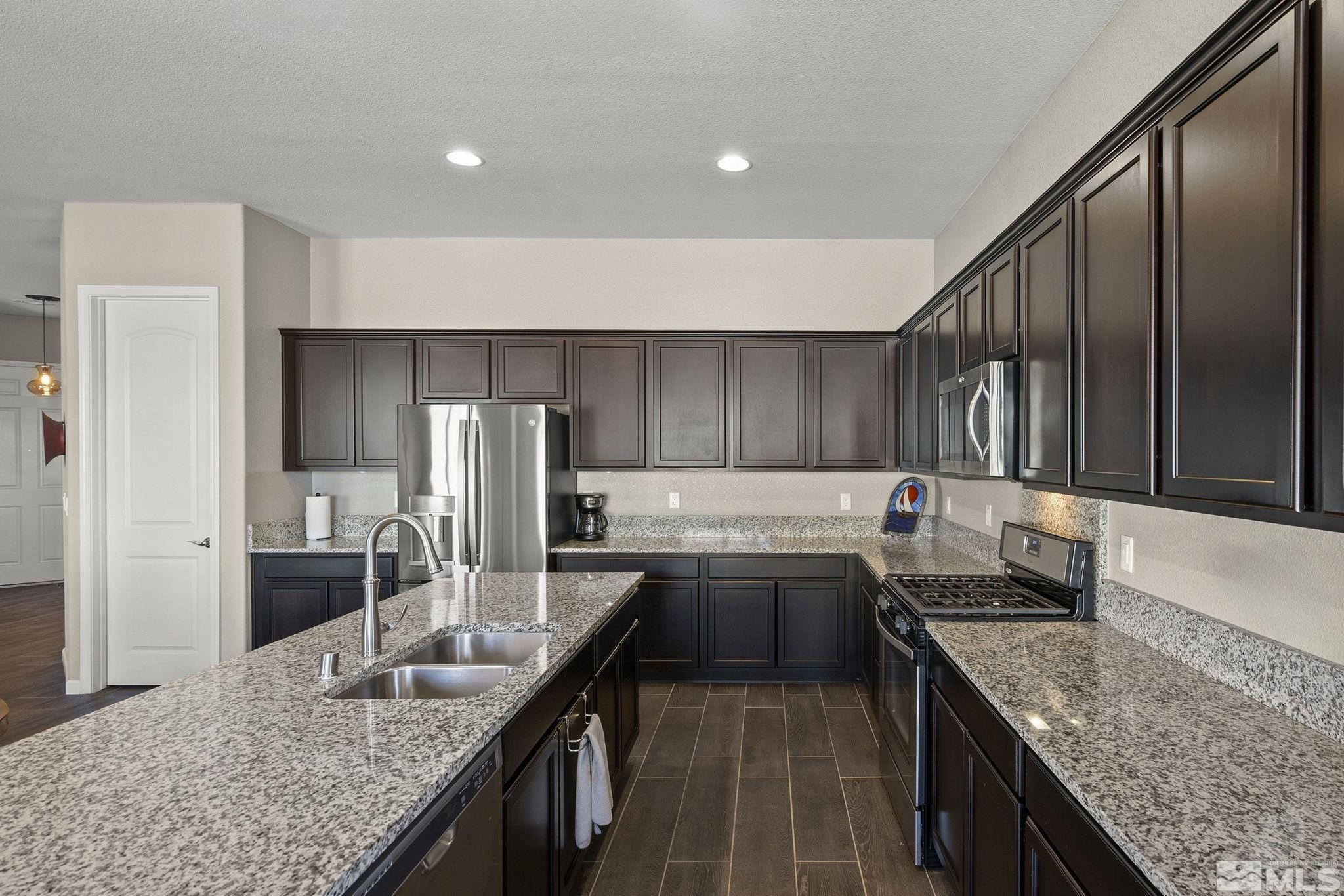 2975 Show Jumper Lane Reno, NV 89521 - Photo 10 of 32 a kitchen with stainless steel appliances granite countertop a sink a stove and a refrigerator