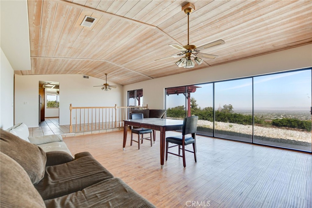 2929 Snow Line Drive Pinon Hills, CA 92372 - Photo 12 of 67 a living room with furniture a ceiling fan and a large window