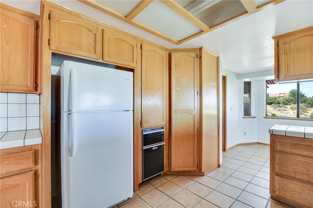 2929 Snow Line Drive Pinon Hills, CA 92372 - Photo 20 of 67 a kitchen with stainless steel appliances granite countertop a refrigerator and a sink