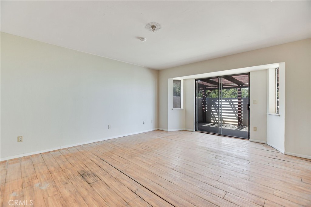 2929 Snow Line Drive Pinon Hills, CA 92372 - Photo 27 of 67 a view of an empty room with wooden floor and a window
