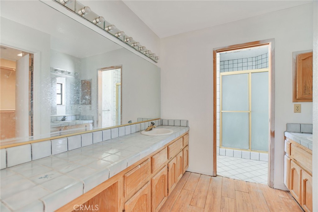 2929 Snow Line Drive Pinon Hills, CA 92372 - Photo 28 of 67 a spacious bathroom with a granite countertop sink a mirror and a shower