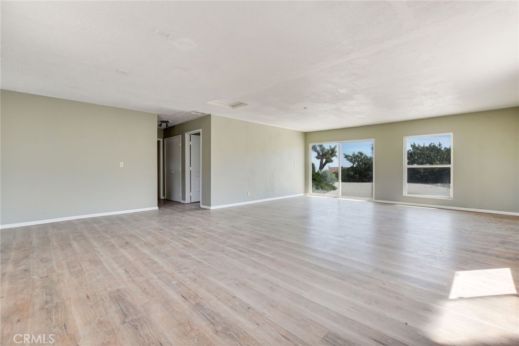 2929 Snow Line Drive Pinon Hills, CA 92372 - Photo 32 of 67 a view of an empty room with wooden floor and windows