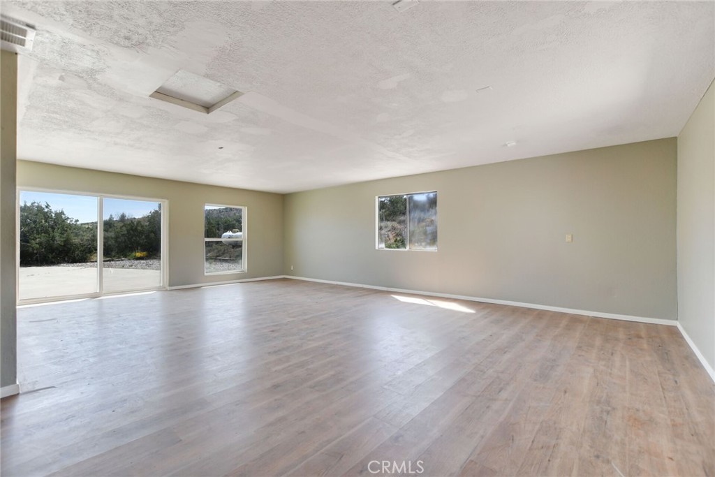 2929 Snow Line Drive Pinon Hills, CA 92372 - Photo 33 of 67 an empty room with wooden floor and windows