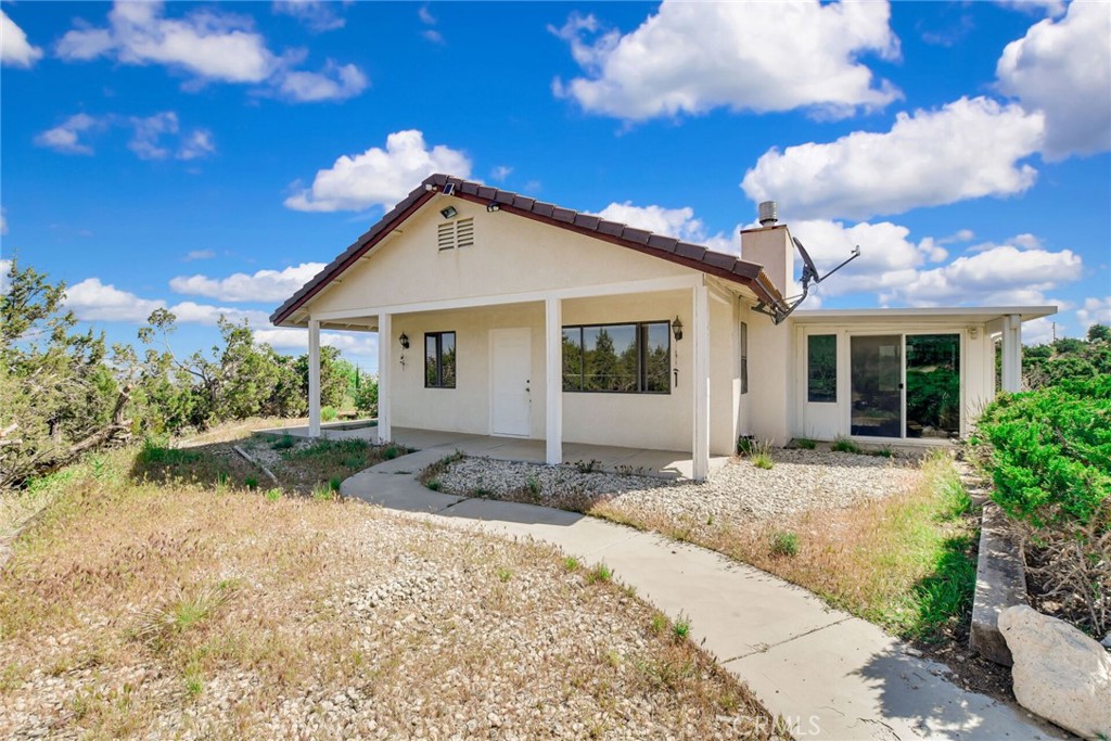 2929 Snow Line Drive Pinon Hills, CA 92372 - Photo 39 of 67 a view of a house with a small yard and potted plants