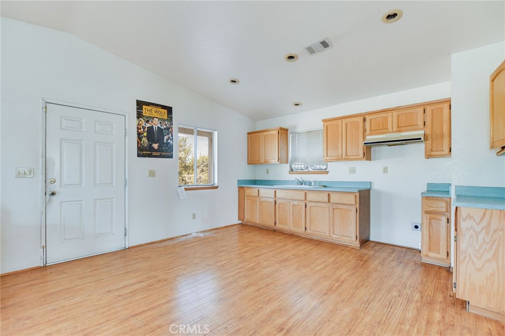 2929 Snow Line Drive Pinon Hills, CA 92372 - Photo 45 of 67 a kitchen with stainless steel appliances granite countertop a stove a sink and a refrigerator with white cabinets
