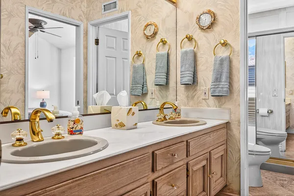 a bathroom with a double vanity sink mirror and toilet