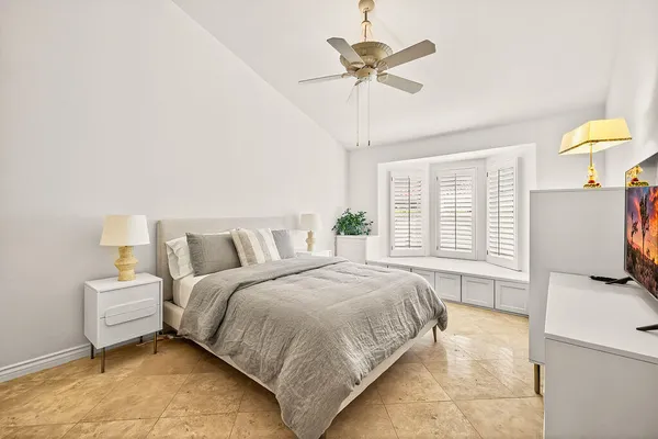 a spacious bedroom with a bed and a chandelier
