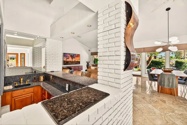 a kitchen with stainless steel appliances kitchen island granite countertop a sink dishwasher a stove and a wooden cabinets