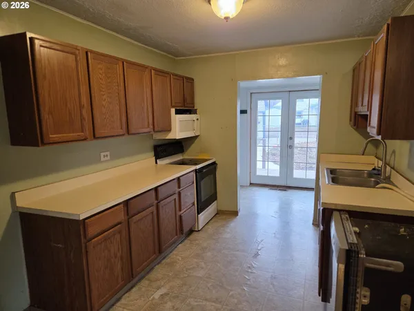 a kitchen with a sink cabinets and a stove top oven