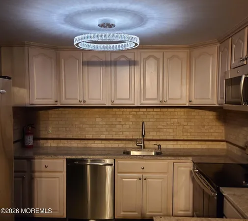 a kitchen with stainless steel appliances granite countertop a sink a stove a microwave and cabinets