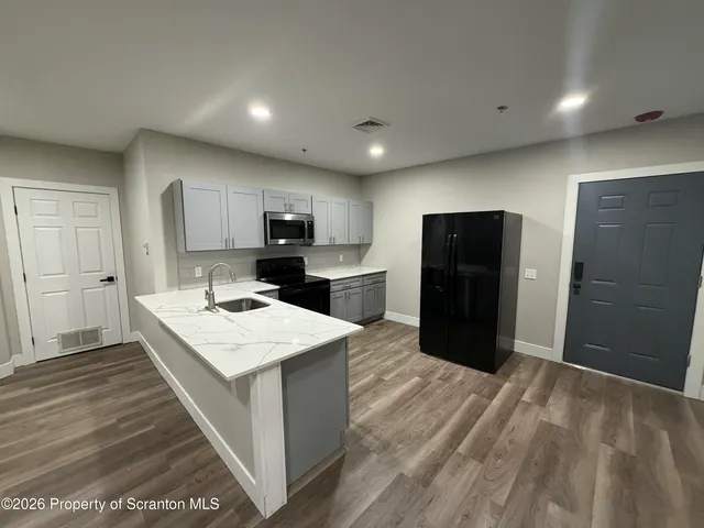 a kitchen with a refrigerator a stove top oven a sink and dishwasher