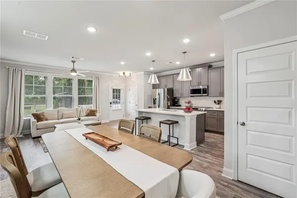 a living room with stainless steel appliances kitchen island granite countertop a sink and cabinets
