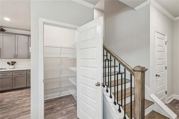 a view of a hallway with wooden floor and staircase