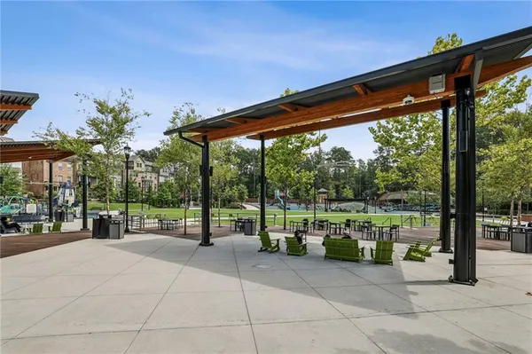 a view of a swimming pool with lawn chairs and plants
