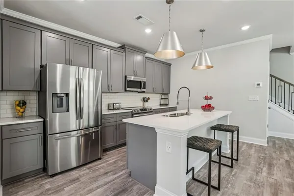 a kitchen with kitchen island a sink stainless steel appliances and cabinets