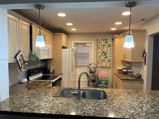 a kitchen with sink refrigerator and cabinets