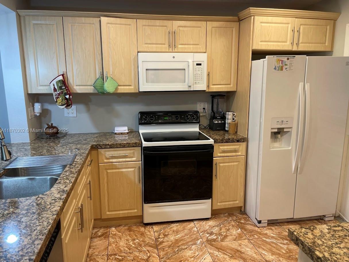 2500 Southwest 81st Avenue, Unit 102 Davie, FL 33324 - Photo 8 of 9 a kitchen with stainless steel appliances granite countertop a refrigerator sink and stove