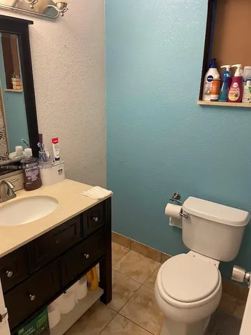 a bathroom with a toilet a sink and mirror