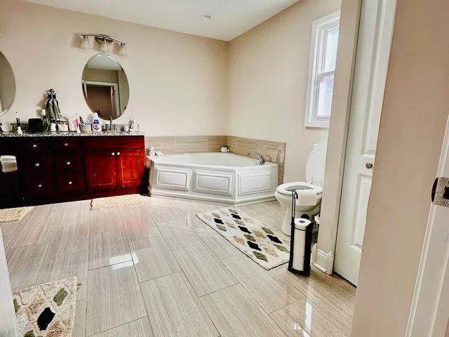 a spacious bathroom with a double vanity sink mirror and shower