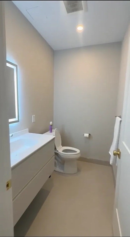 44-46 Temple Place, Unit 3 Boston, MA 02111 - Photo 7 of 11 a bathroom with a toilet a sink and mirror