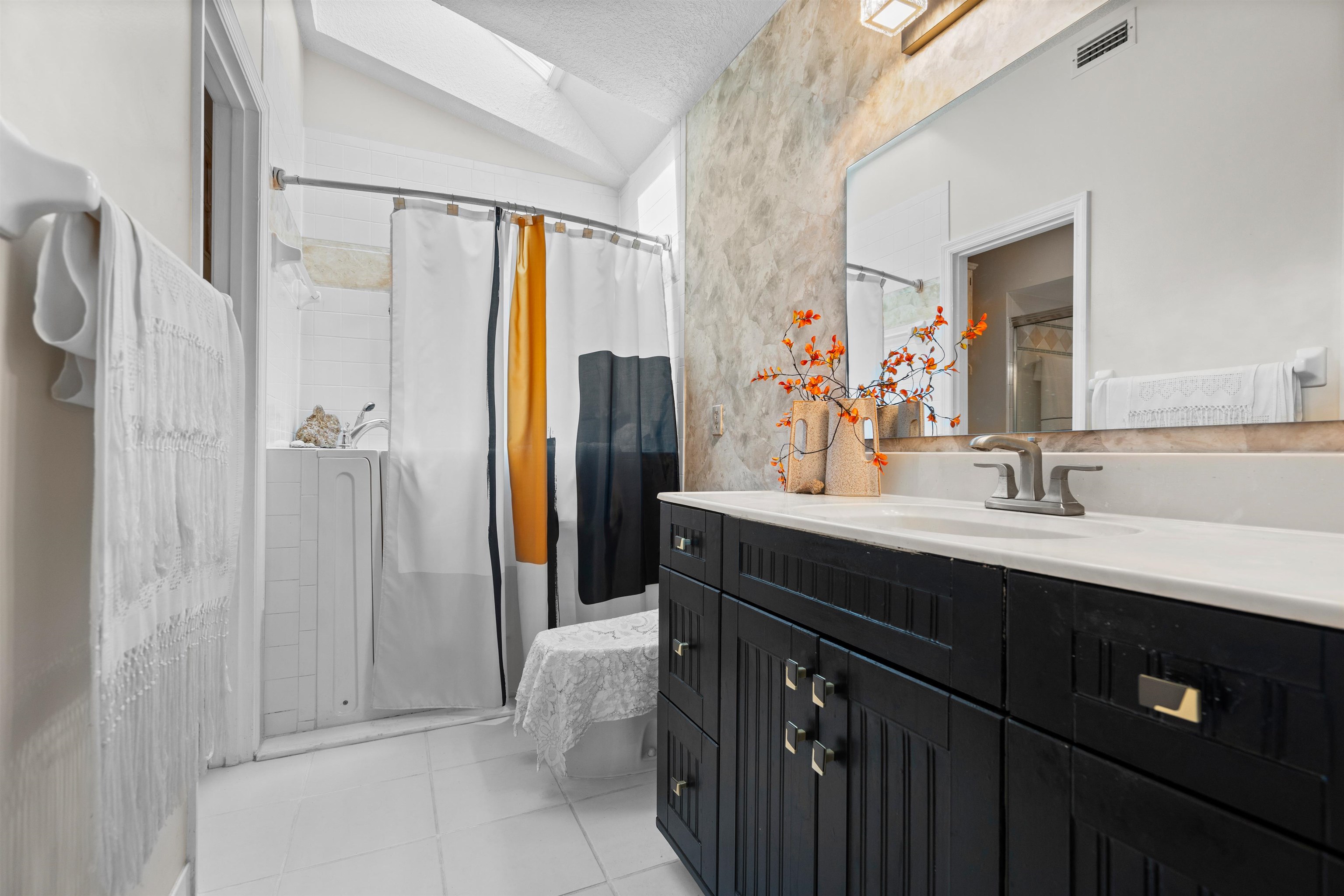 9244 July Lane St. Augustine, FL 32080 - Photo 20 of 66 a bathroom with a double vanity sink a mirror a bathtub and shower