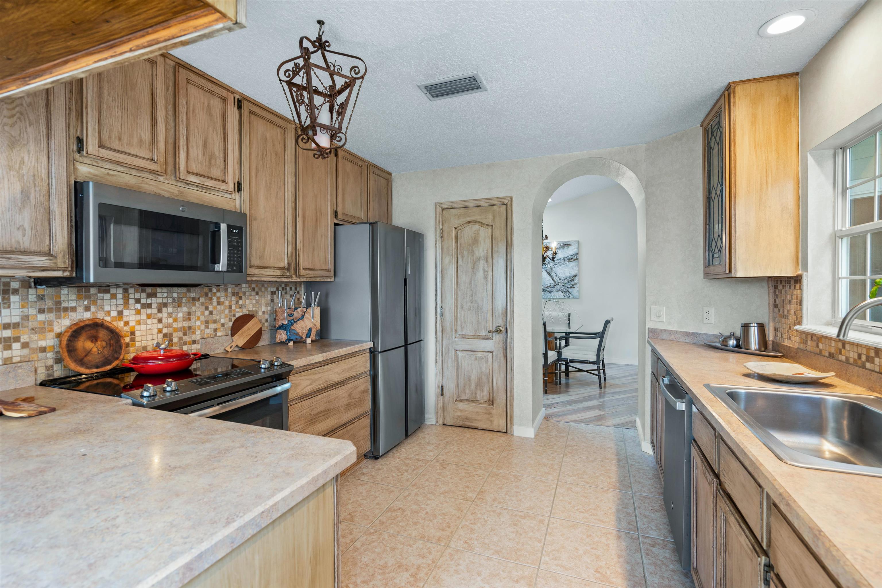 9244 July Lane St. Augustine, FL 32080 - Photo 10 of 66 a kitchen with stainless steel appliances granite countertop a sink stove and refrigerator